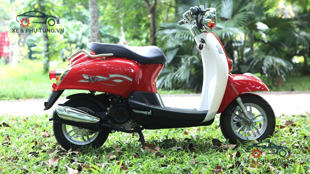 Một chiếc xe tay ga 50cc màu đỏ chụp tại công viên
